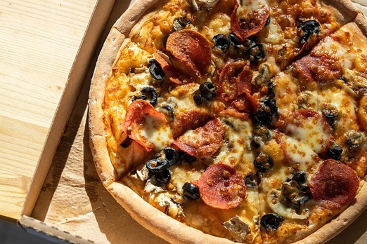 Frisch gebackene Pizza mit Salami, Käse und Gemüse – jetzt online bestellen bei Pizza Joy Salzburg